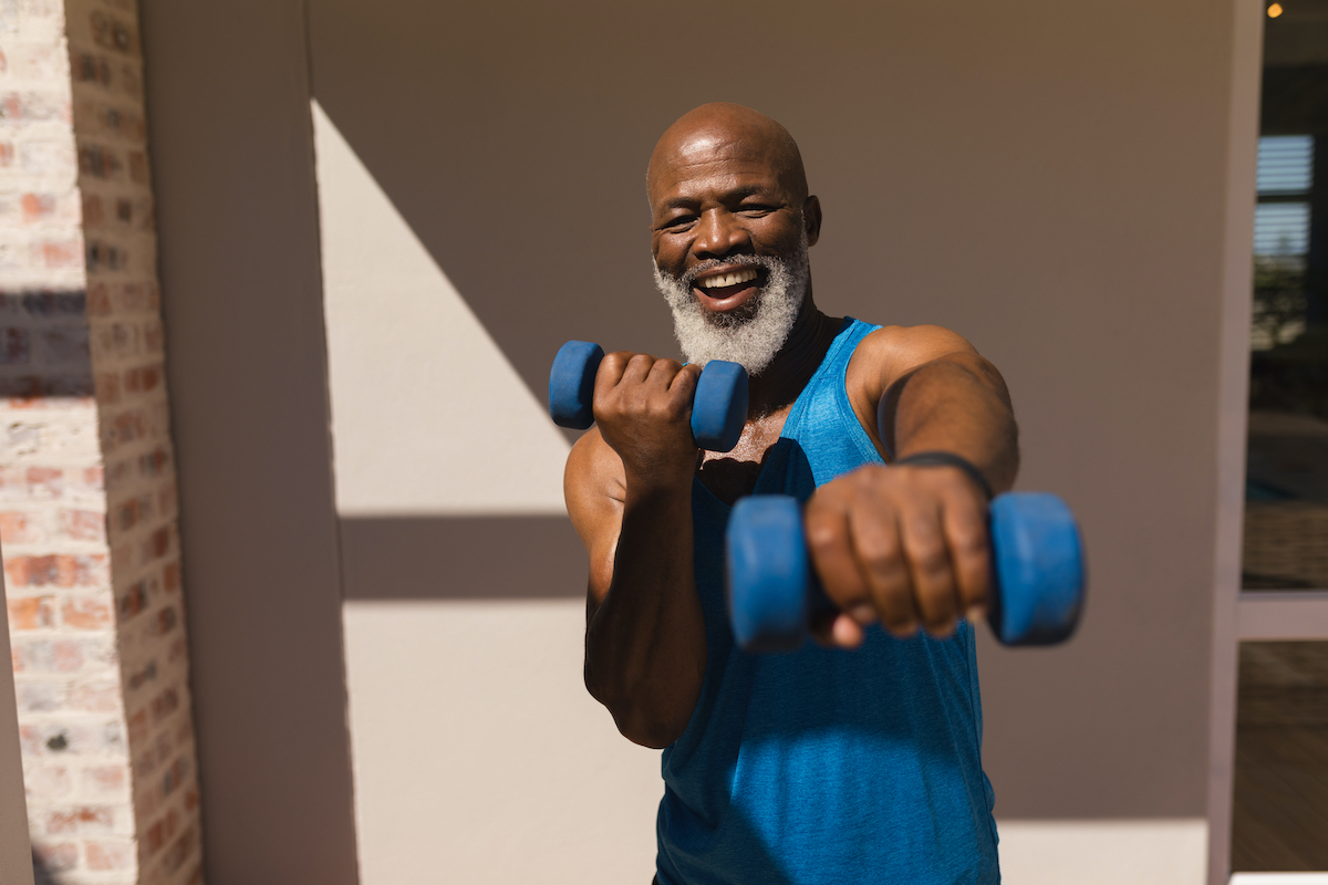 A senior woman stretches during her workout. Mature woman exercising. Portrait of fit elderly woman doing stretching exercise in park. Senior sportswoman making stretch exercises