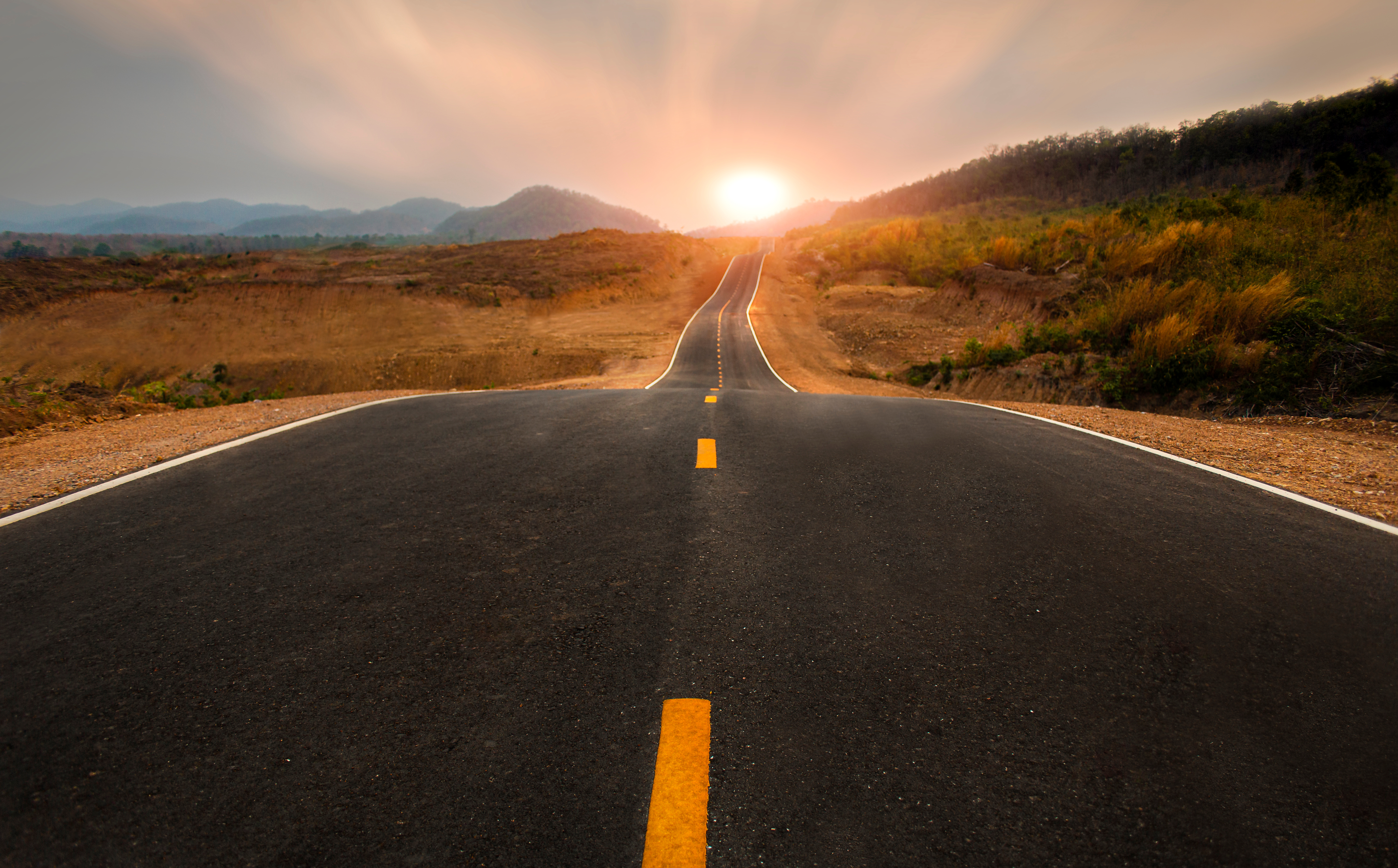 a long winding road at sunset / symbol of change