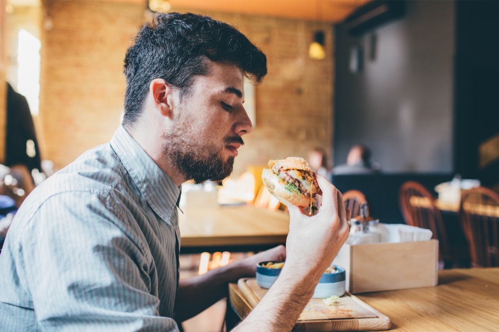 man eating hamburger partner