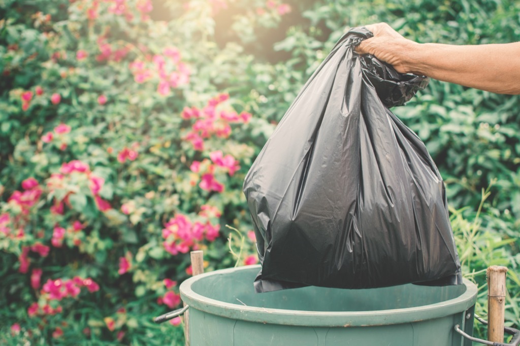 man throwing garbage in trash can