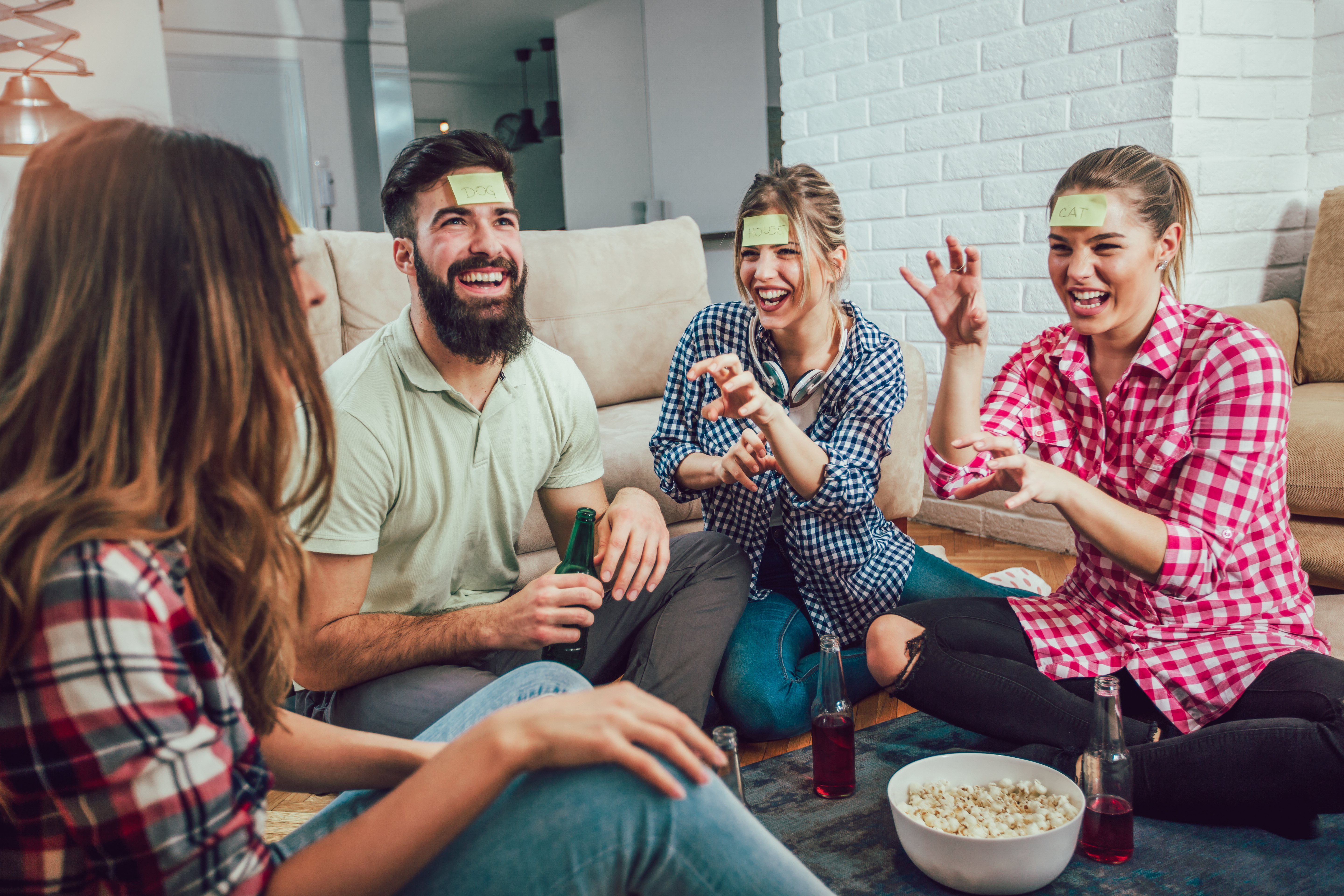 group of friends drinking beer and playing party games at home