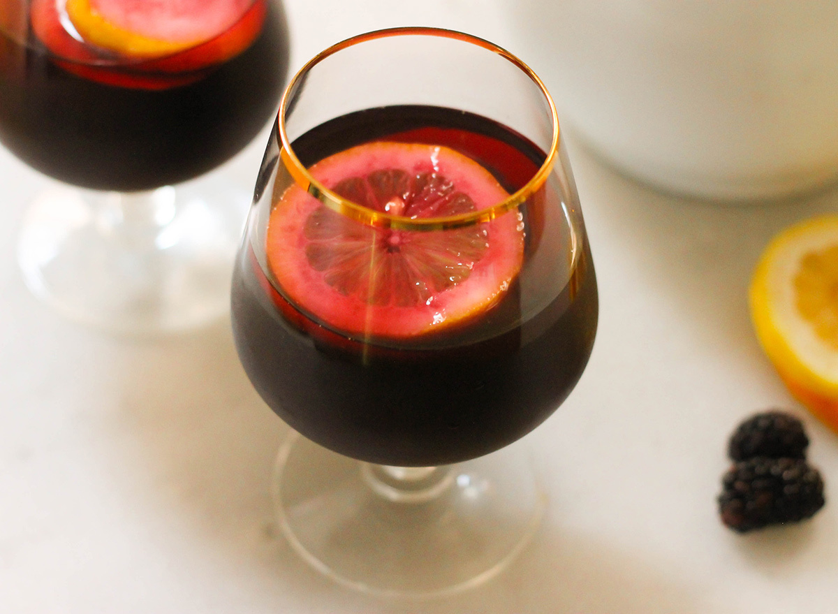 Cup of homemade blackberry sangria with slices of lemon and oranges