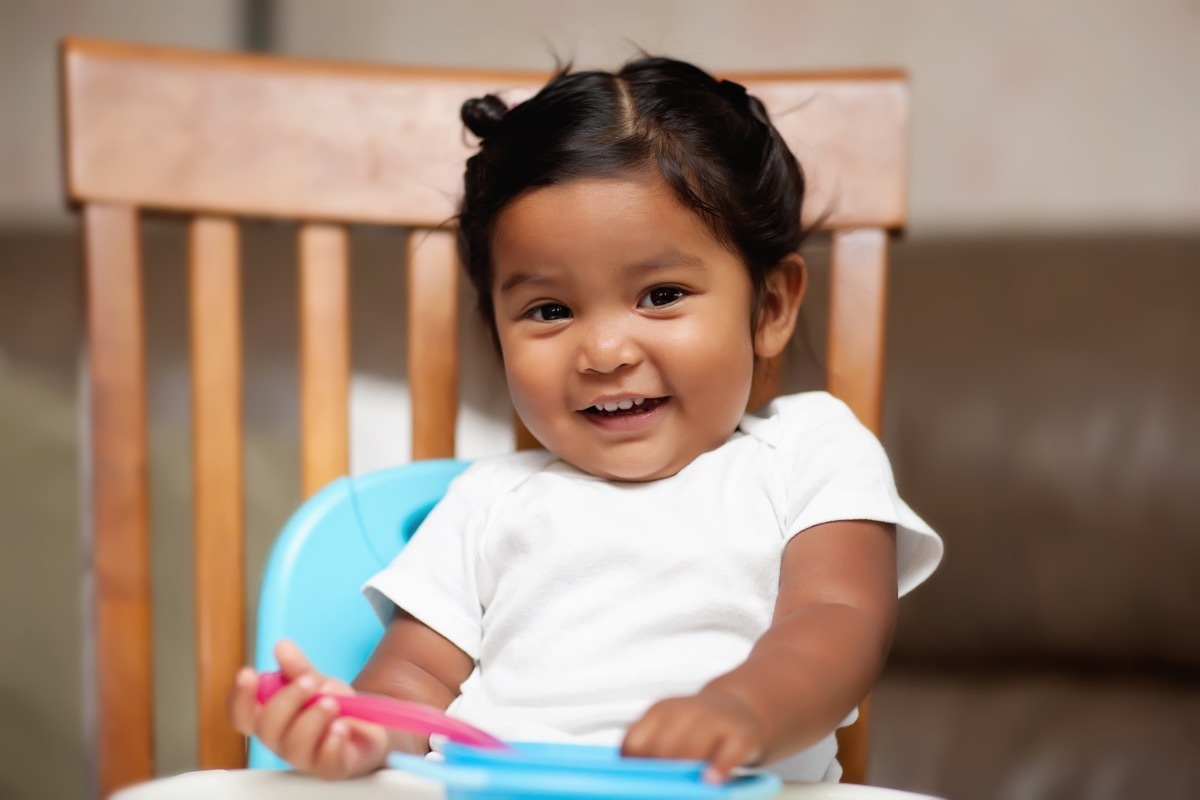 cute baby girl sitting in high chair