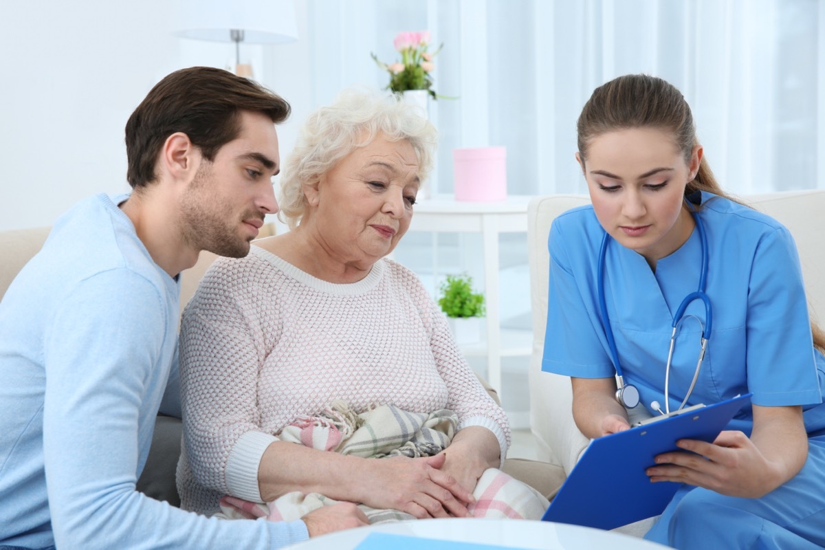 Nurse talking with grandmother and her grandson indoors