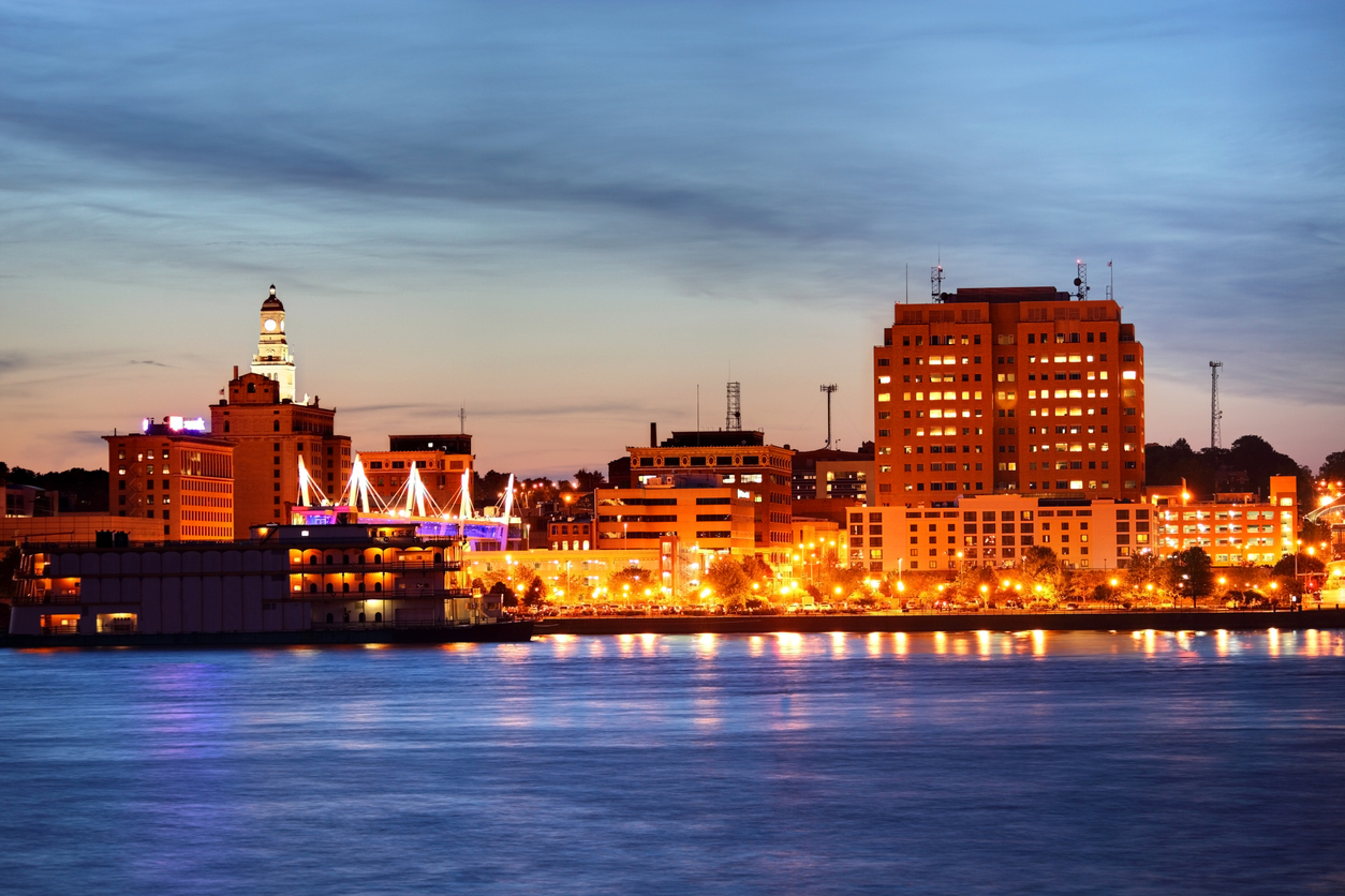 The skyline of Davenport, Iowa at sunset with the Mississippi River in the foreground