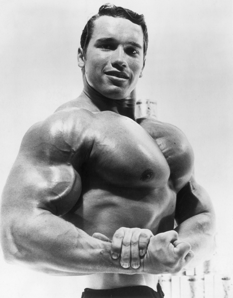 Arnold Schwarzenegger flexing muscle in an ad for a German protein product circa 1967