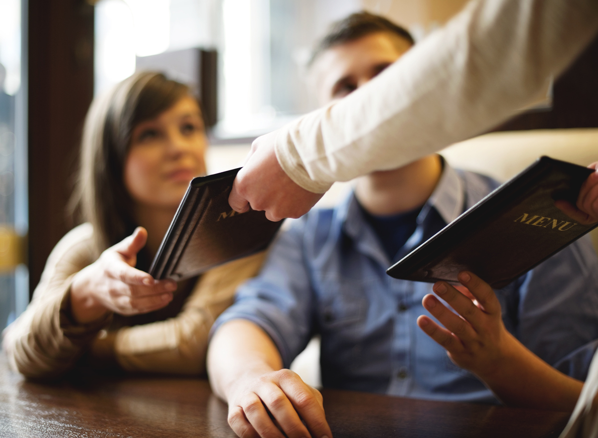 Waiter handing menu to customers