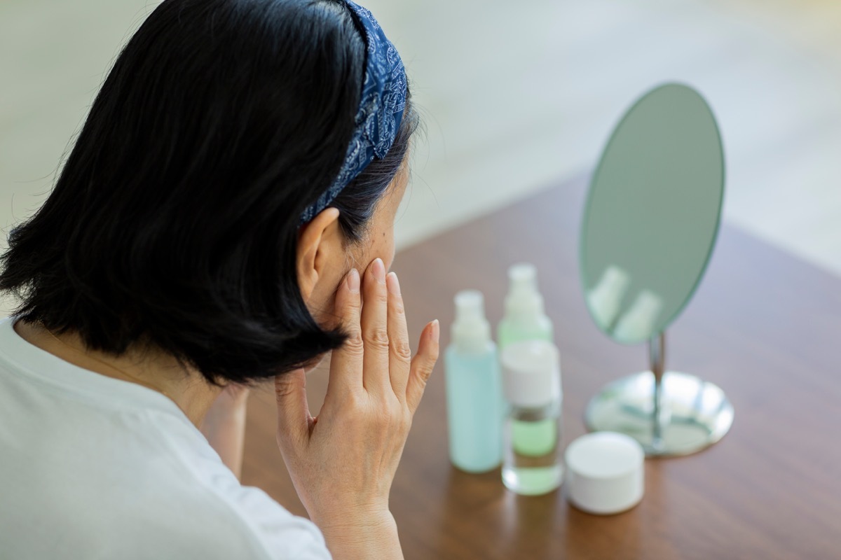 older woman looking at her dry skin Signs Your Metabolism is Slow