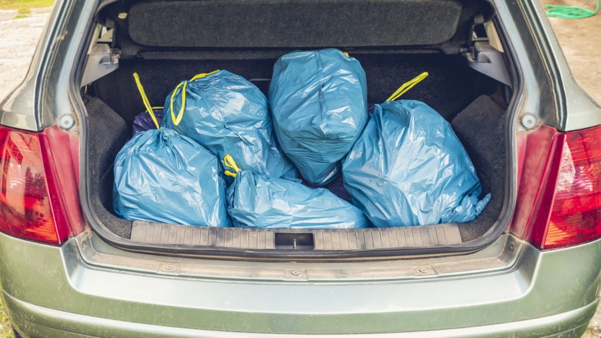 trunk full of blue plastic garbage bags