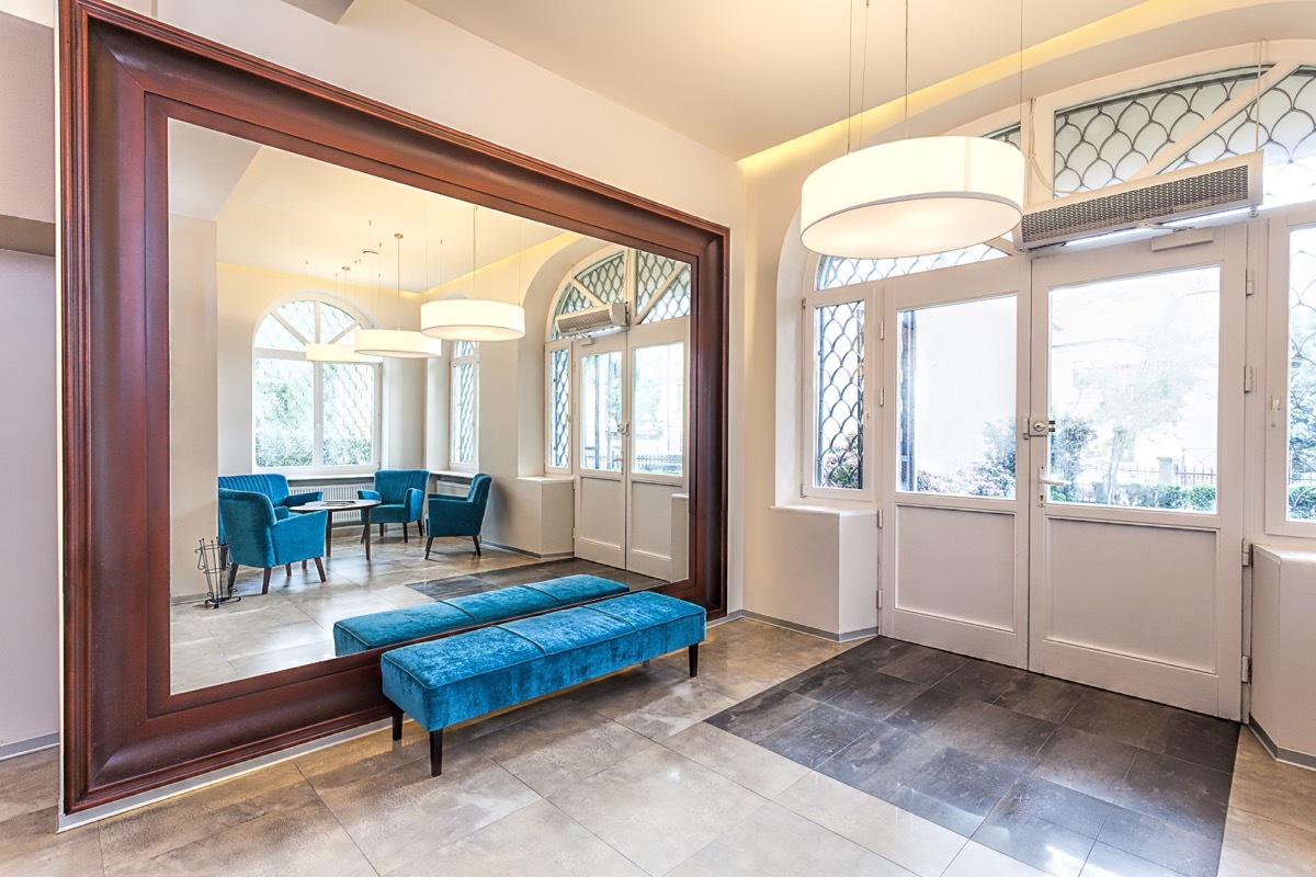 home entryway with large mirror and green bench