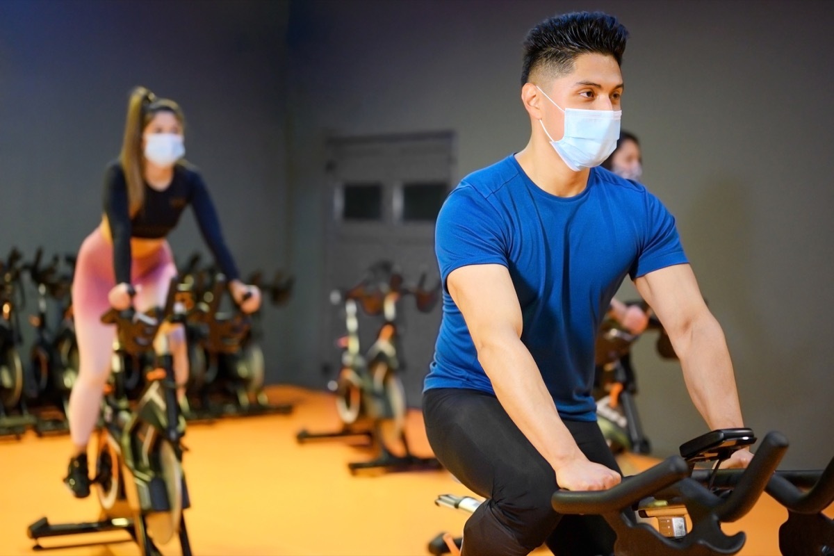 people cycling indoors during covid pandemic, wearing masks