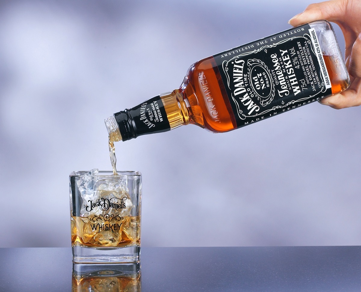 A hand pouring Jack Daniel's in a glass