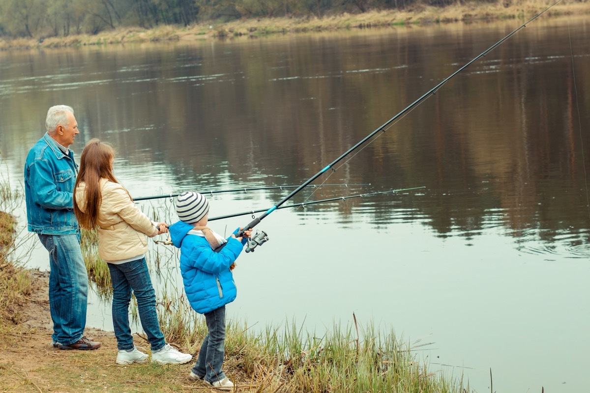 Grandfather fishing with his granddaughters