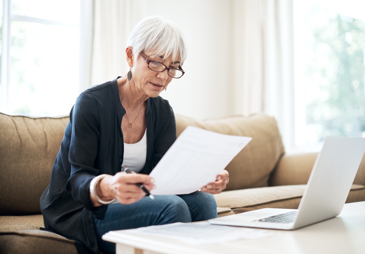 Cropped shot of a senior woman going through her finances while sitting on the sofa at home