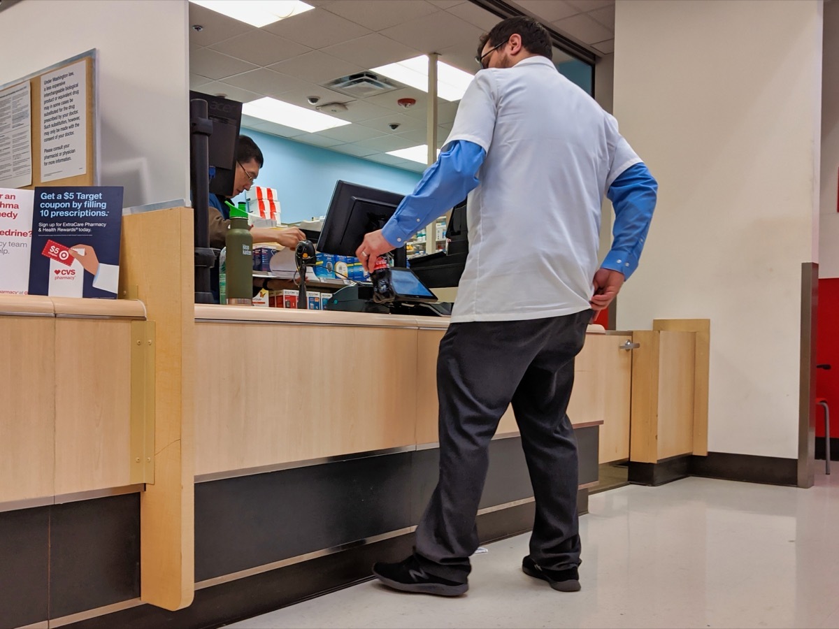 ebruary 2020: Man making a purchase at the CVS pharmacy cash register inside a Target store.