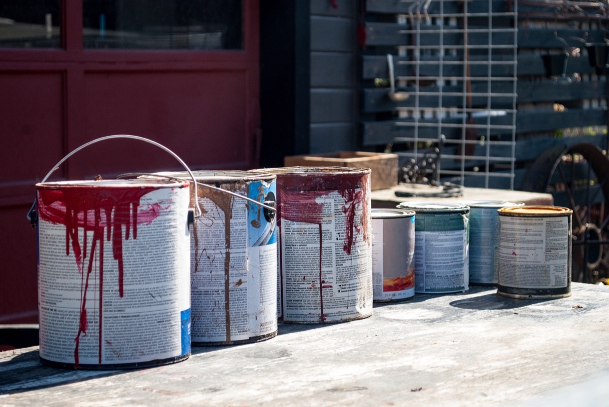 Old Paint Cans in front of Garage