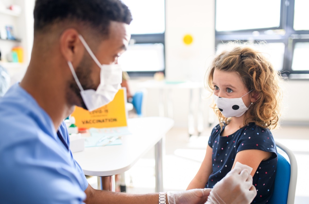 Child with face mask getting vaccinated