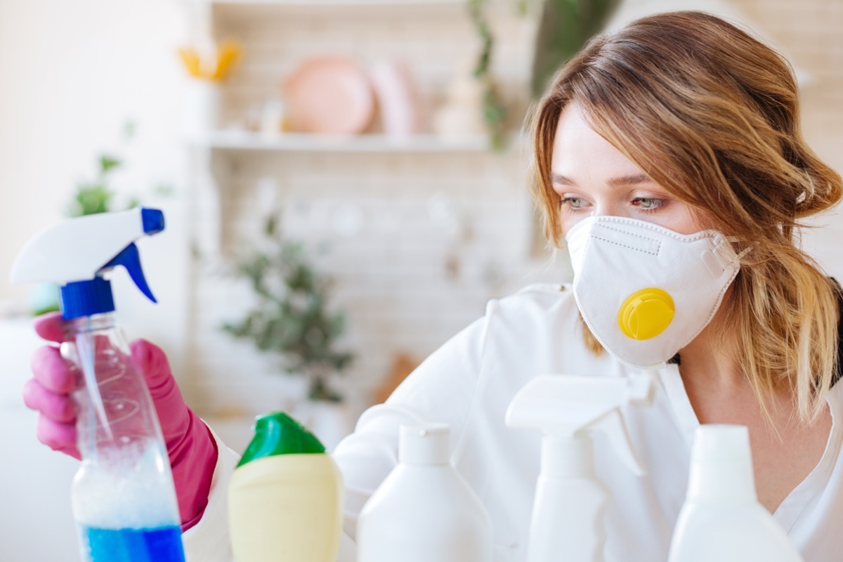 woman wearing a protective mask while taking a cleansing agent