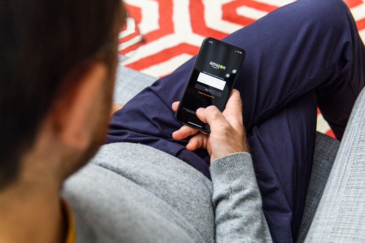 LONDON, UK - SEP 21, 2018: Man using the new Apple iPhone Xs with the immense OLED retina display and a12 bionic chip, looking over the app application Amazon Prime video