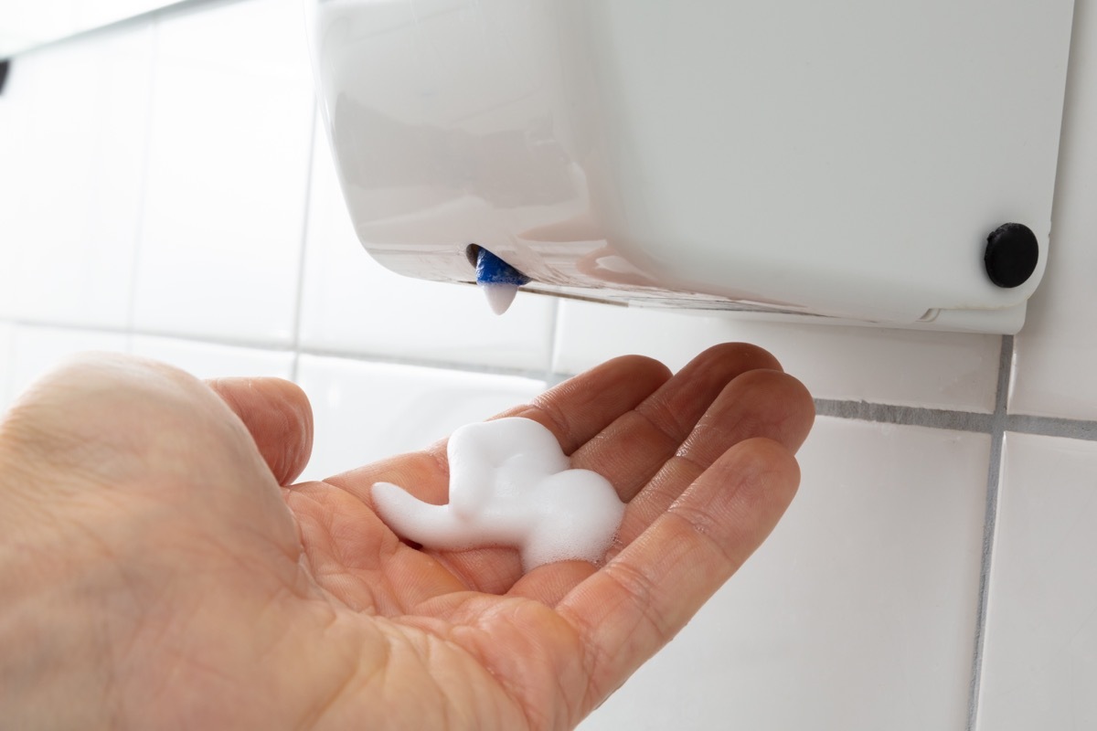 Person's Hand With Liquid Soap Dispenser