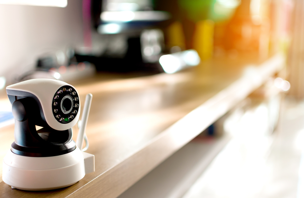 A security camera sitting on a shel in a living room