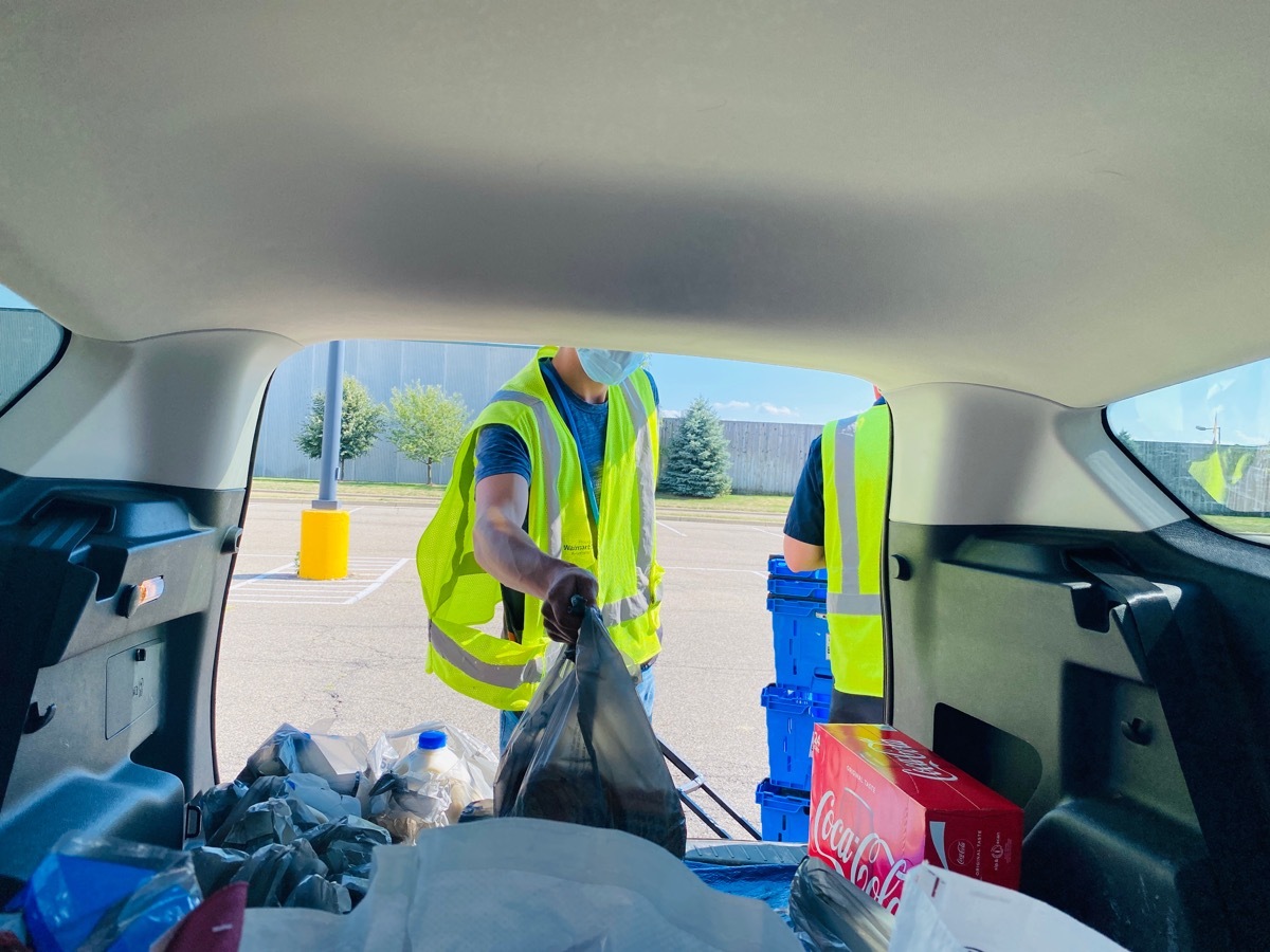 store employees loading groceries at a pickup. People can order groceries online and pick up at a designated time.