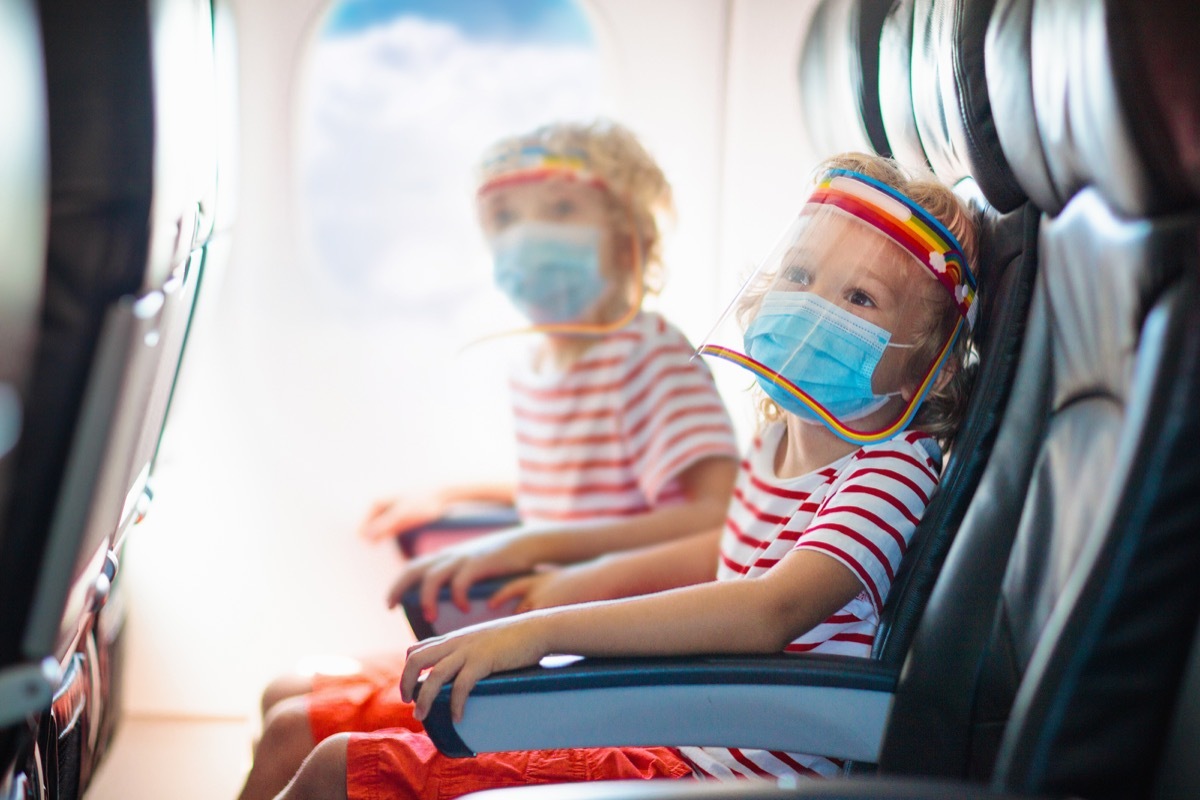 Children wearing masks and face shields on airplane