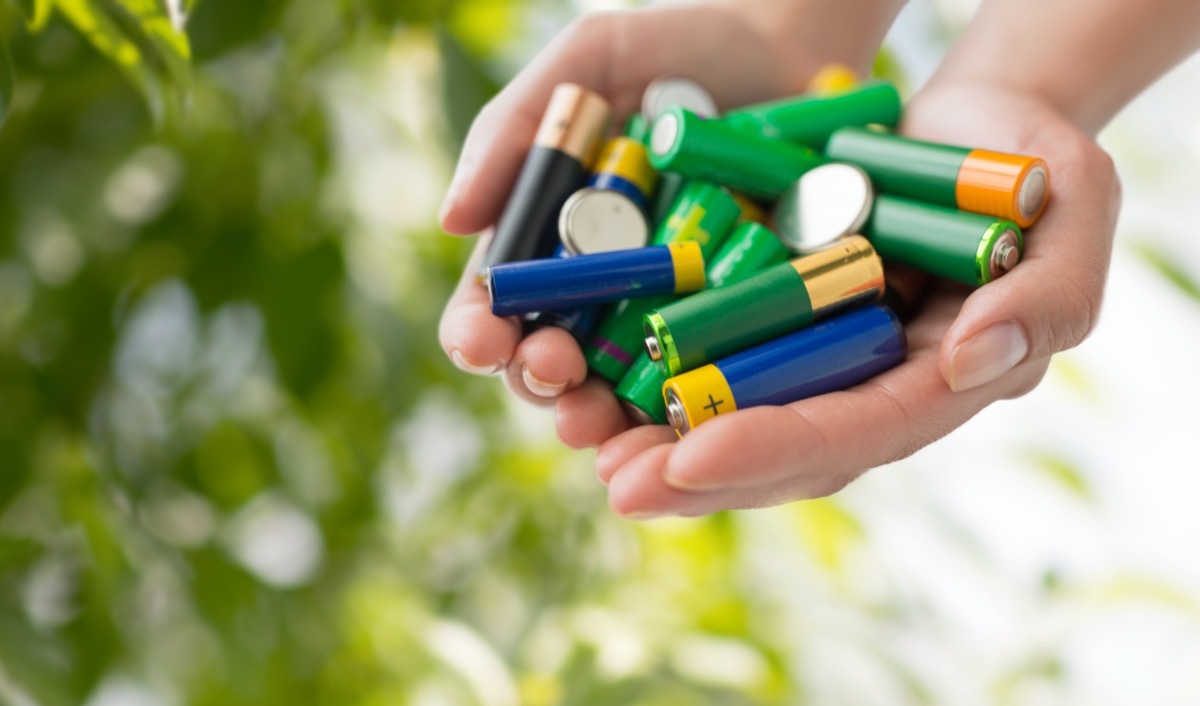 hands holding alkaline batteries