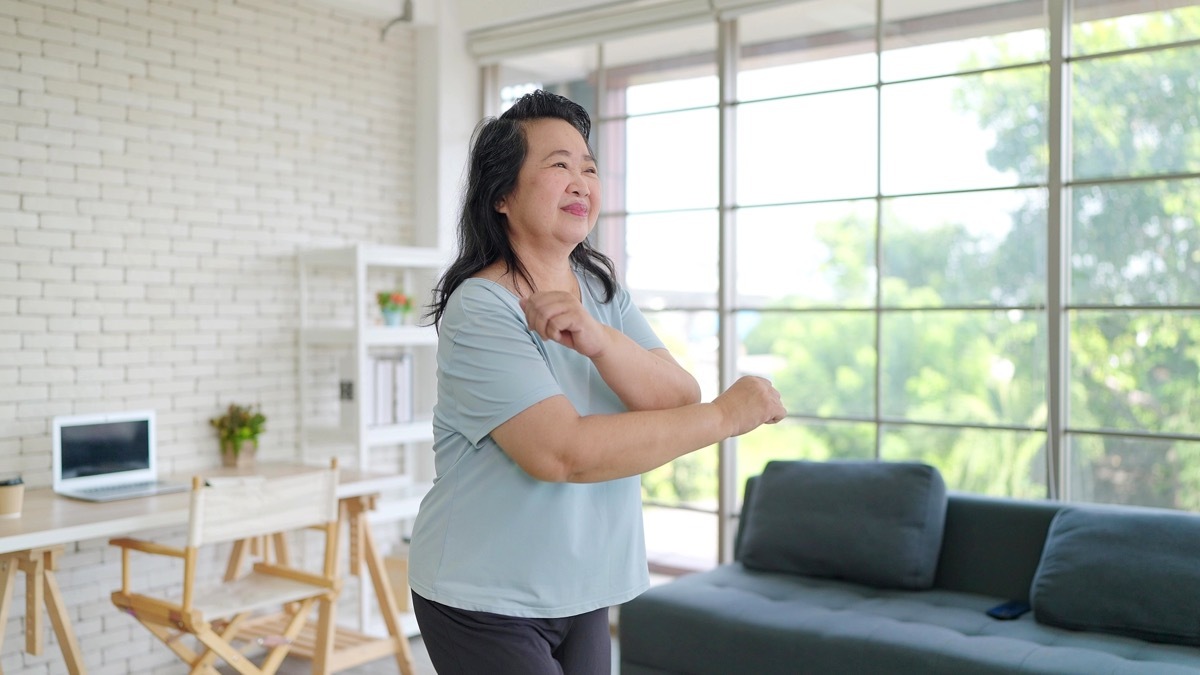 Woman doing warm up exercises at home. 