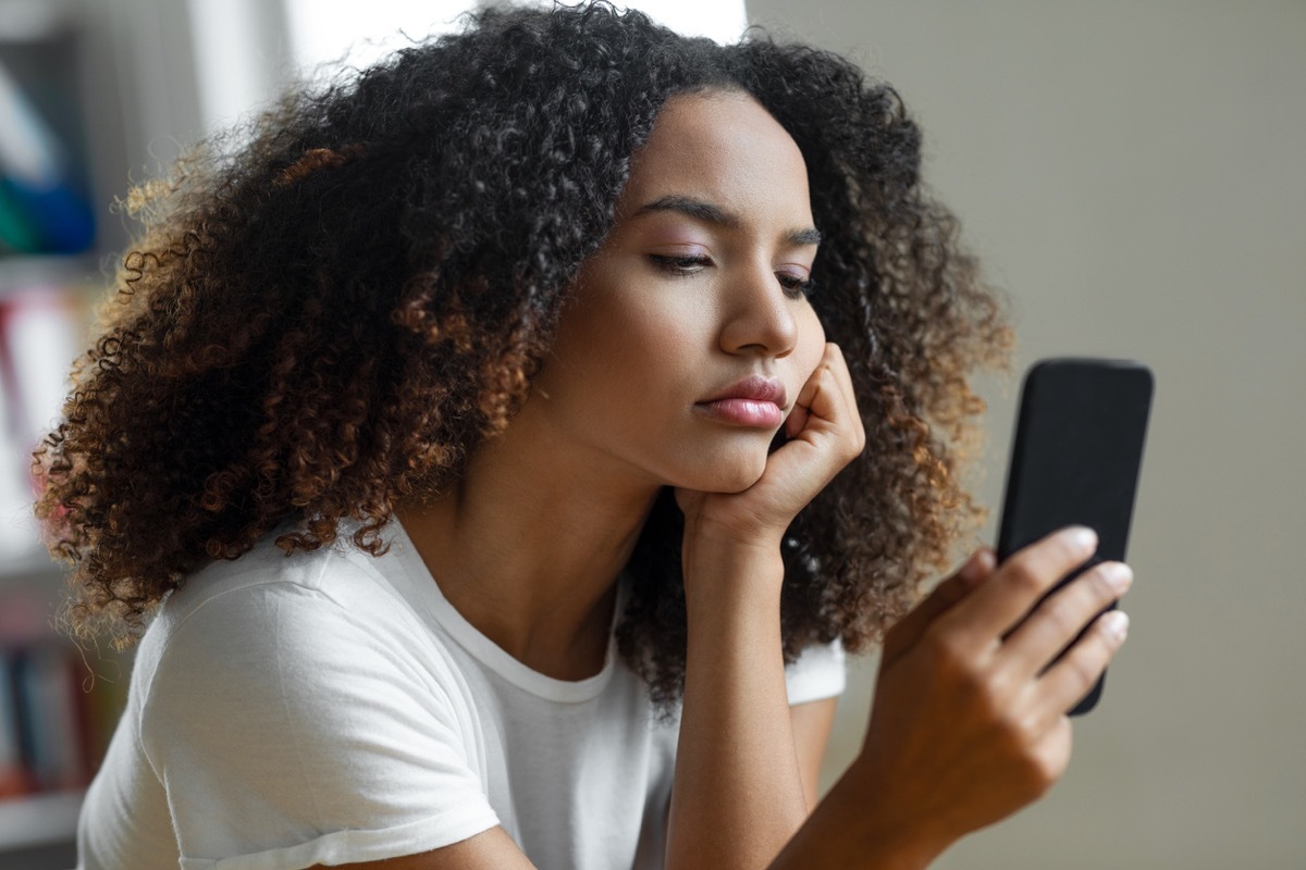 woman disappointed looking at phone