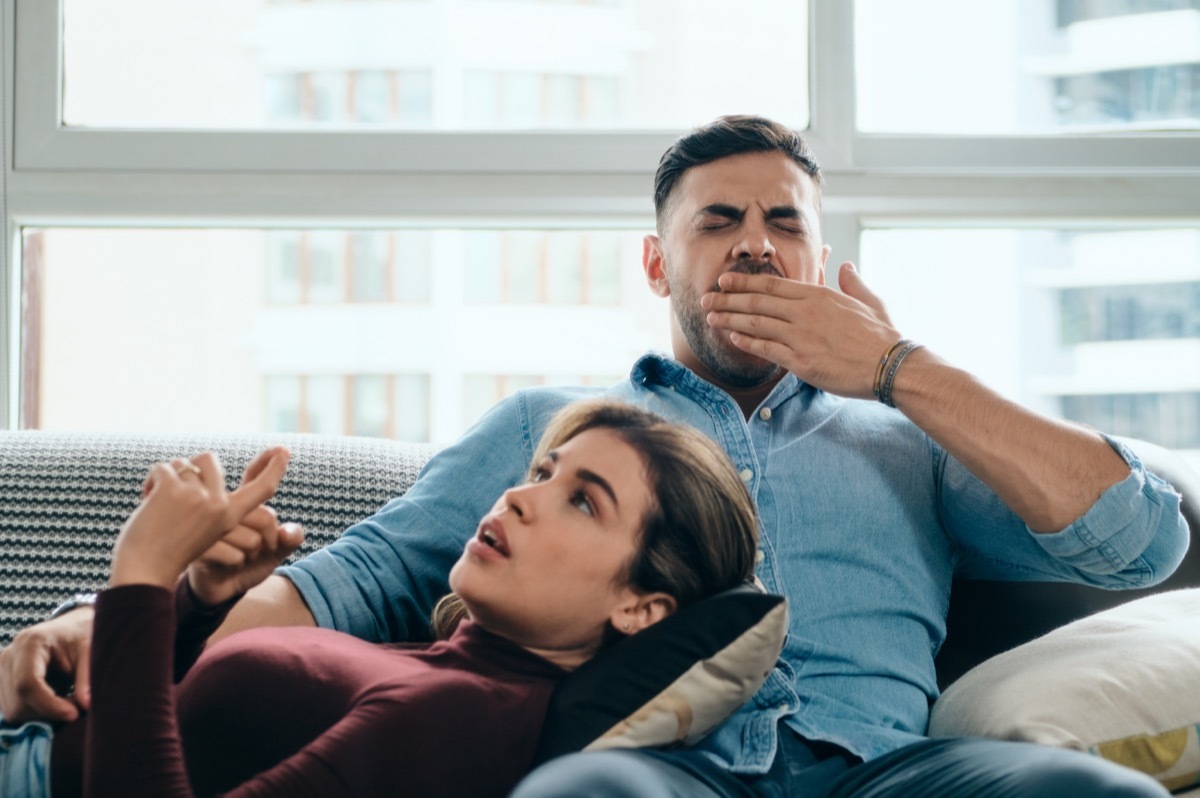 man yawning and interested in partner