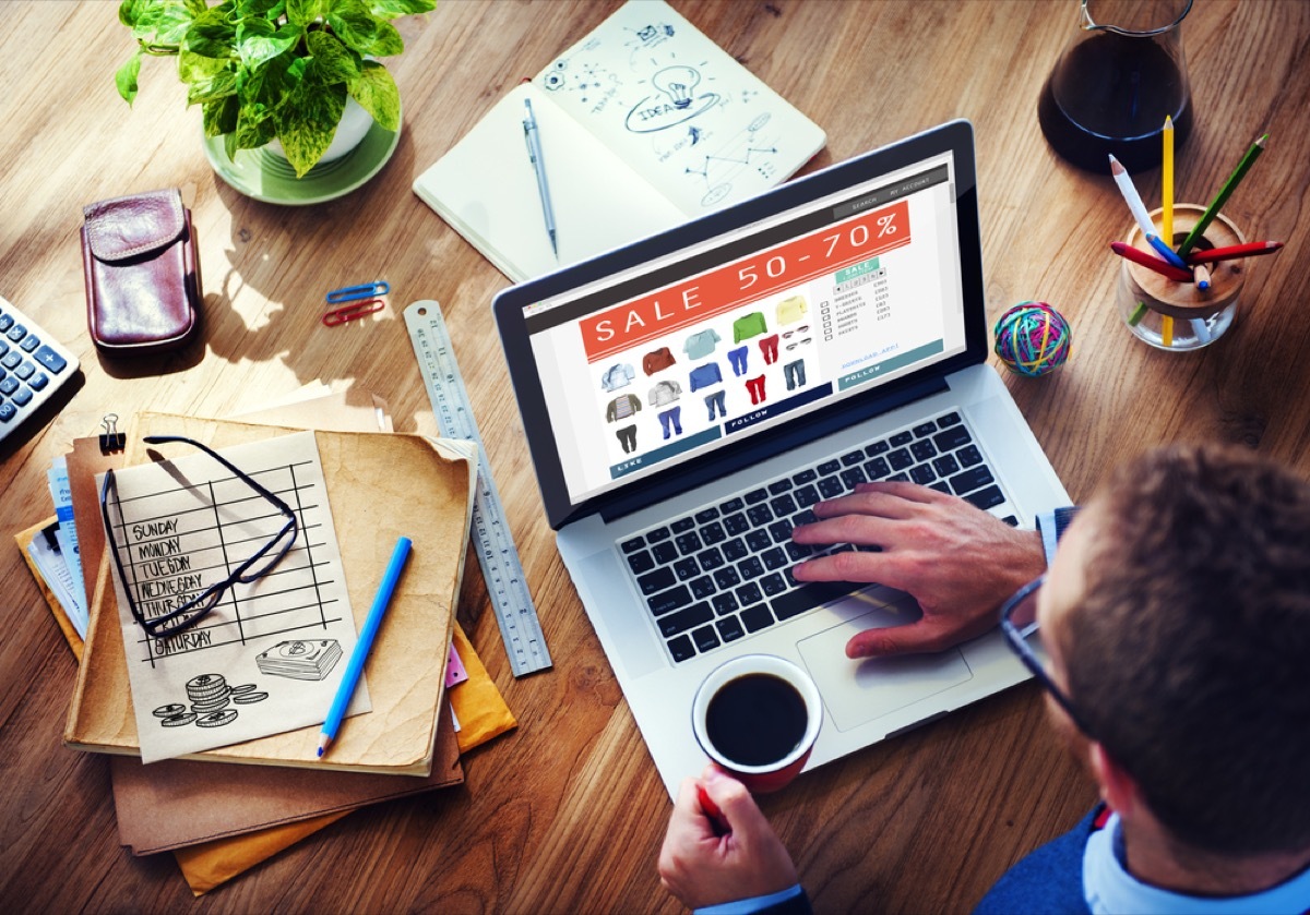 black man looks at online sale on laptop while online shopping