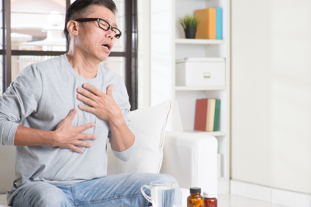 man clutching his chest and coughing men's health concerns over 40