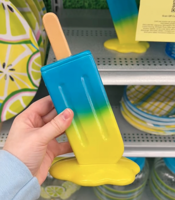 shopper holding up blue and yellow popsicle decor at Michaels