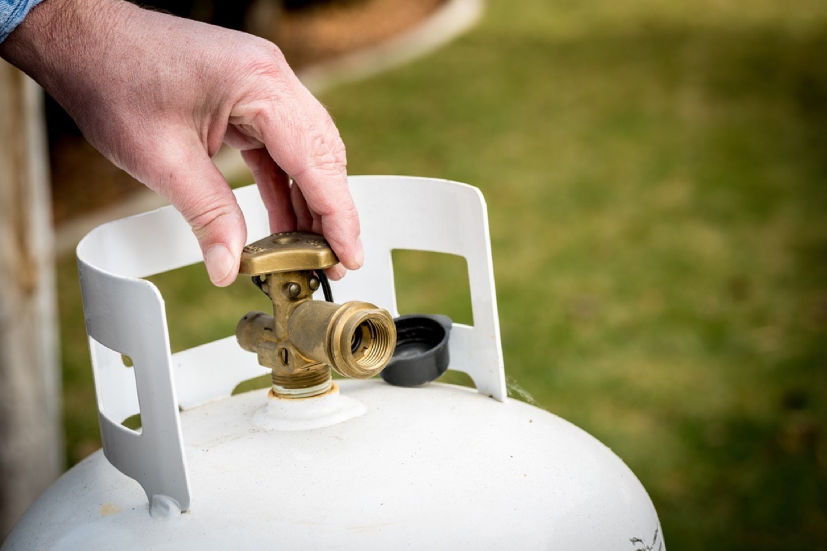 man closing a propane tank, things you shouldn't store in your basement