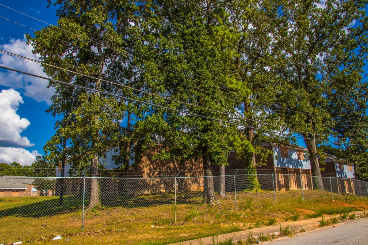 Boarded up apartment, trees, and fence in College Park, Georgia