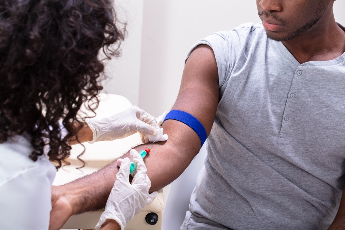 Close-up Of Doctor Taking Blood Sample From Patient's Arm