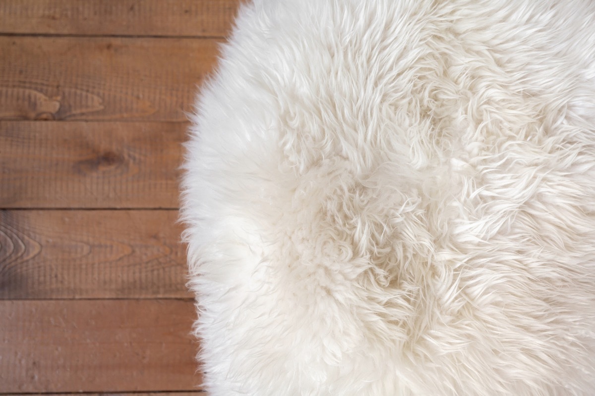 Rough wood floor and white fur rug. New Year or Christmas background. Greeting card.