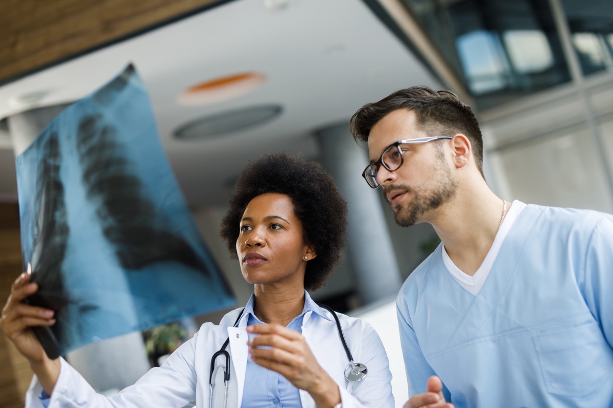 Medical experts cooperating while analyzing medical scan in the hospital