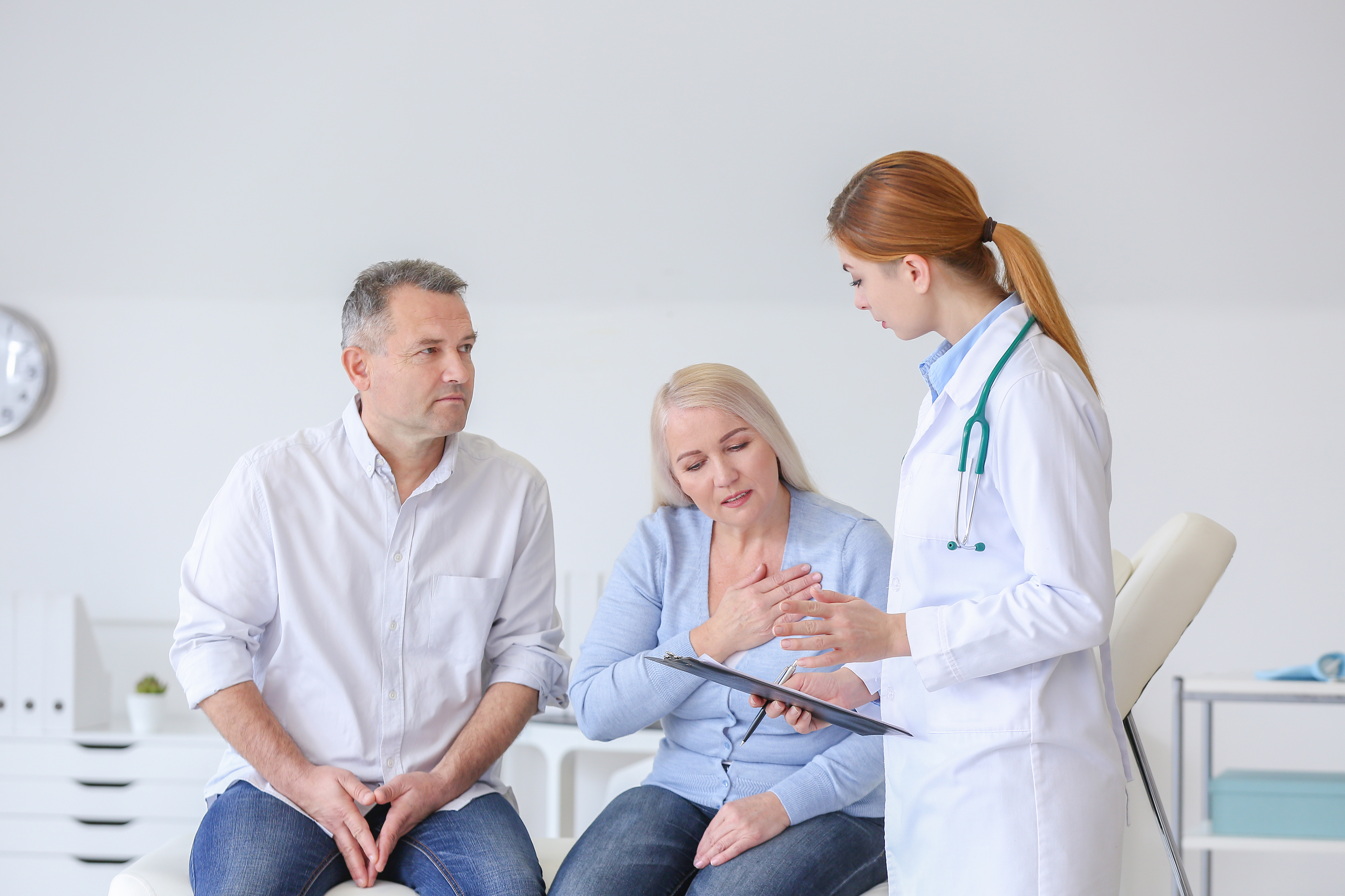 Middle aged couple talking to young doctor