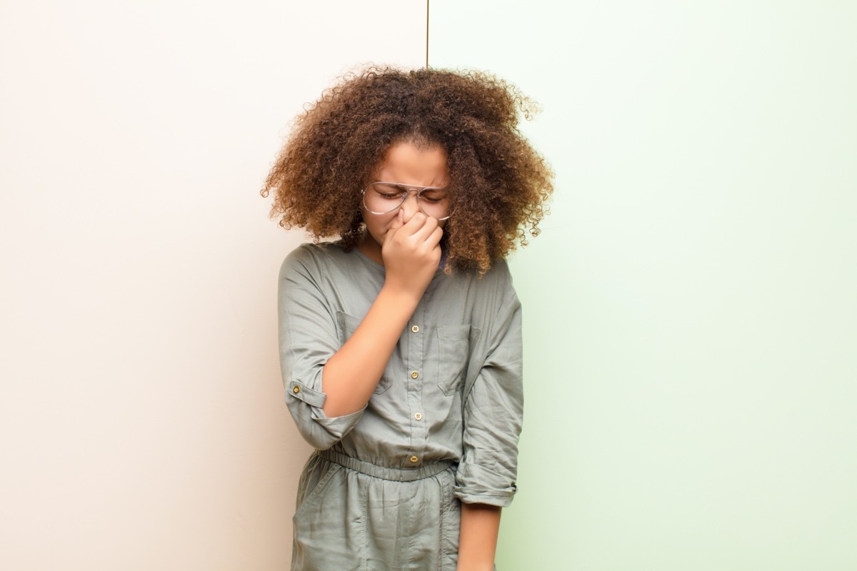 little girl holding nose