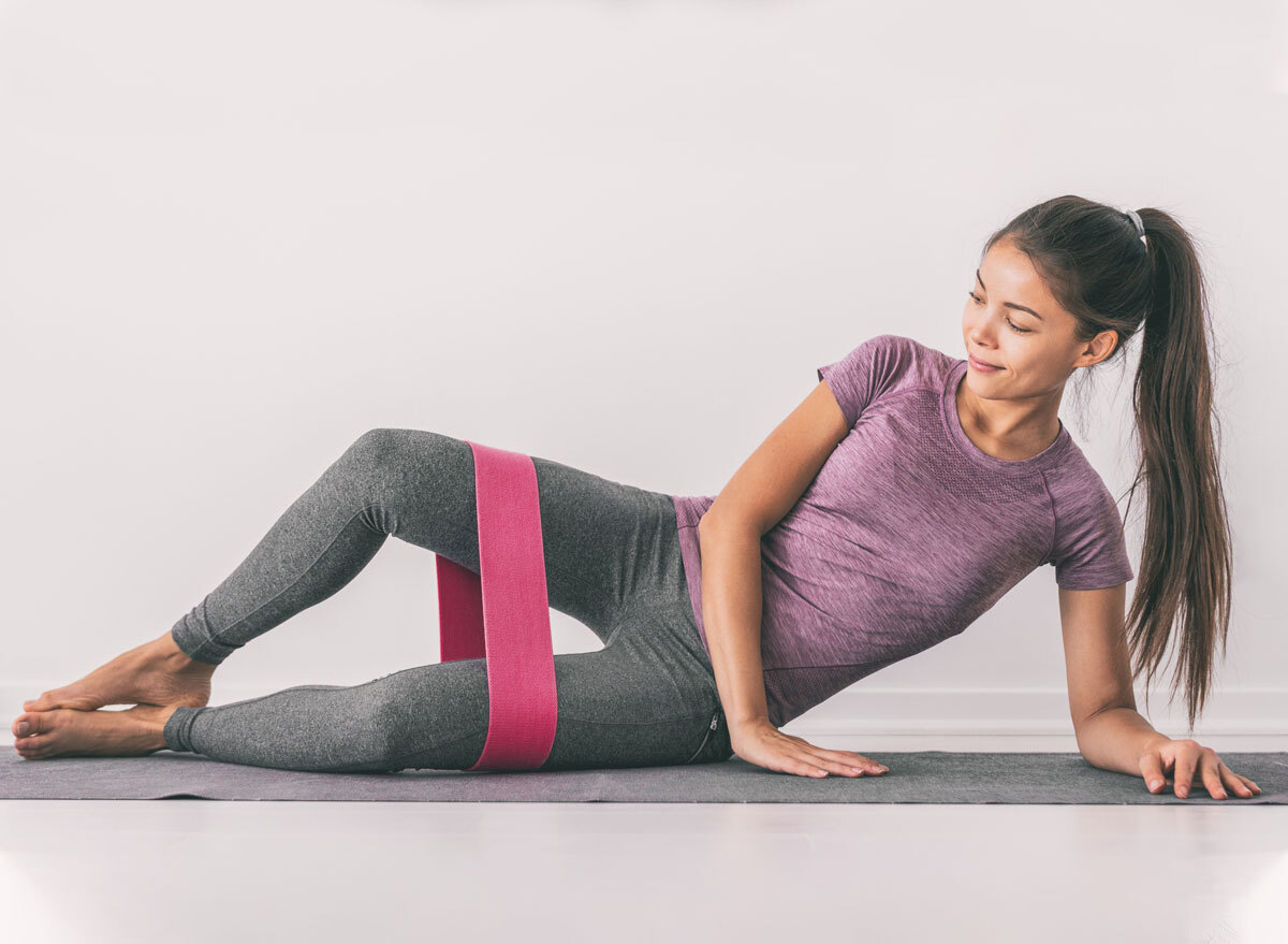 Woman strengthening thighs by using resistance band