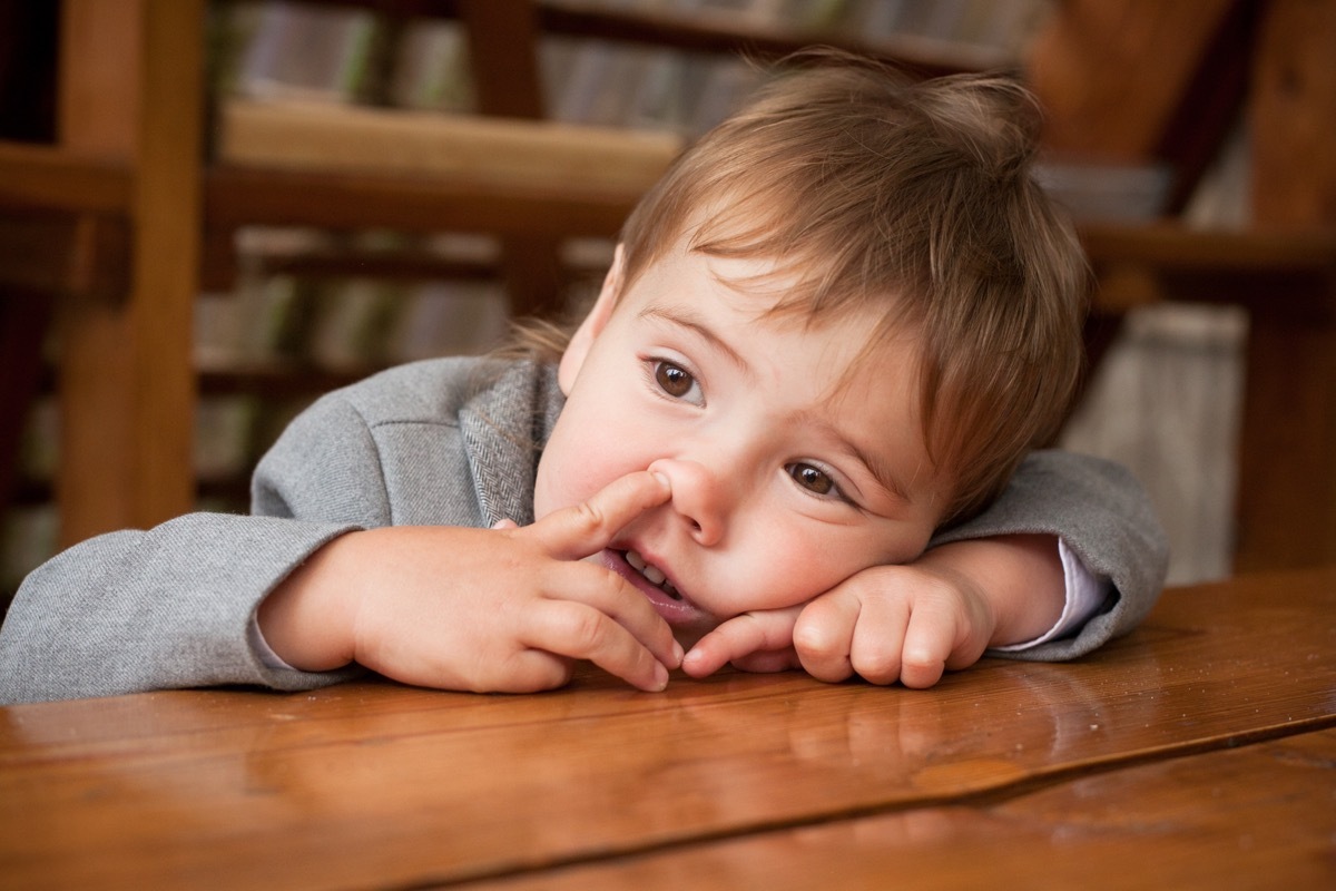 Young child picking nose