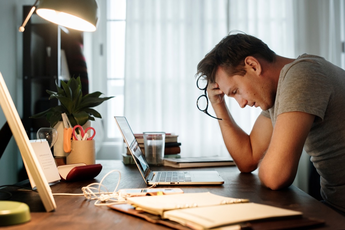 Man stressed while working on laptop