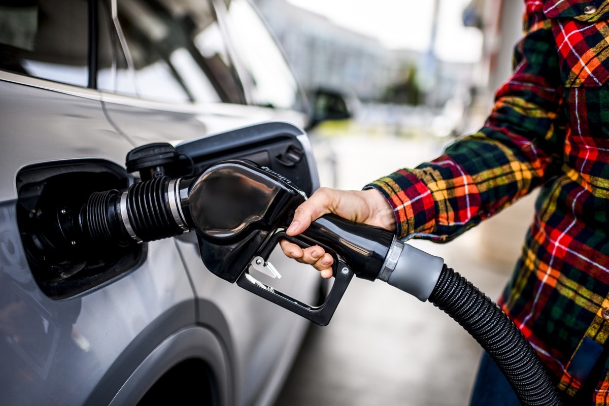 customer pumping gas at gas station