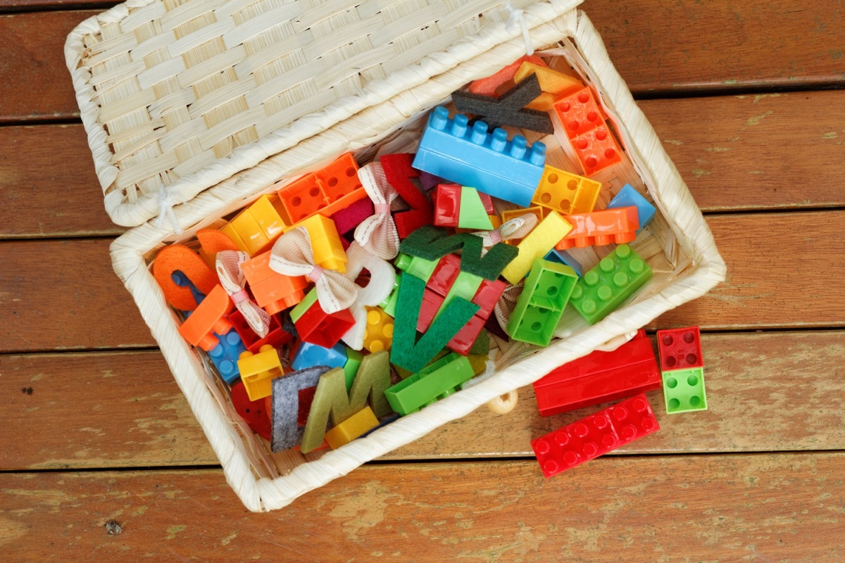 wicker toy box full of legos and toys