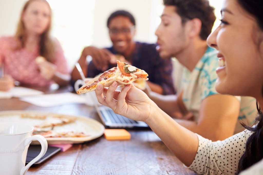 office workers eating pizza in a meeting