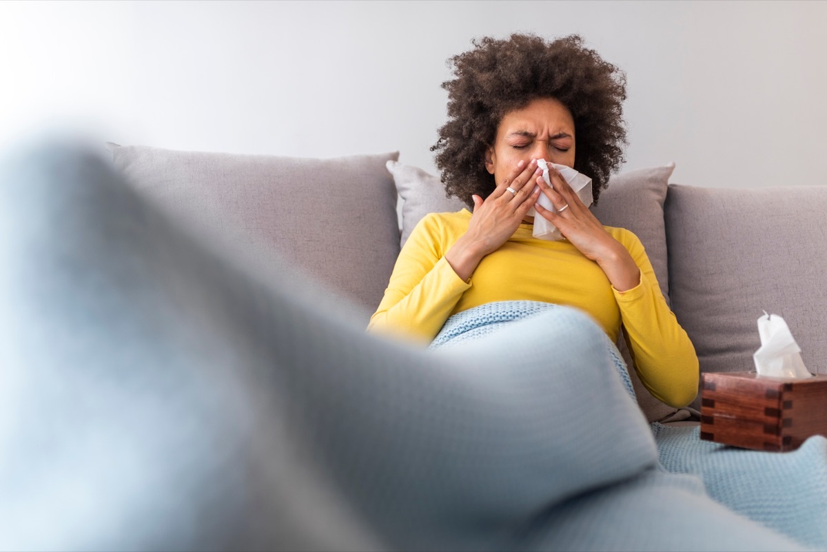 Sick woman sneezing and blowing nose