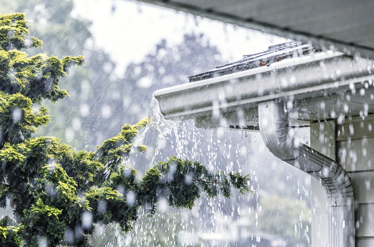 Gutters on a house overflowing during a torrential rain storm