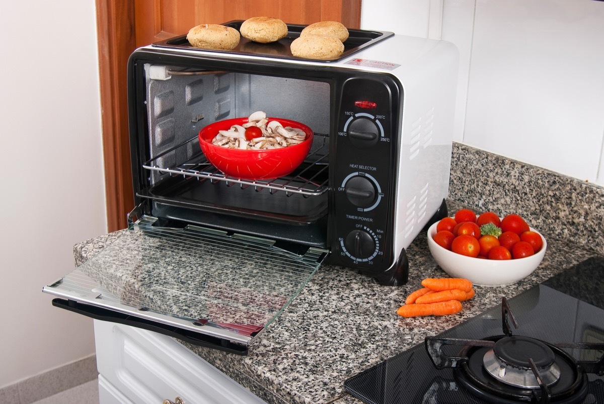 red bowl of mushrooms in toaster oven on kitchen counter